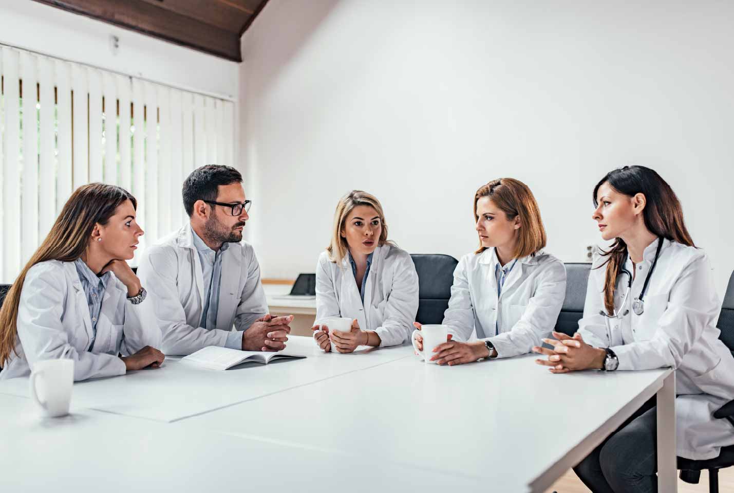 8.1 medical-team-sitting-discussing-table-office-01